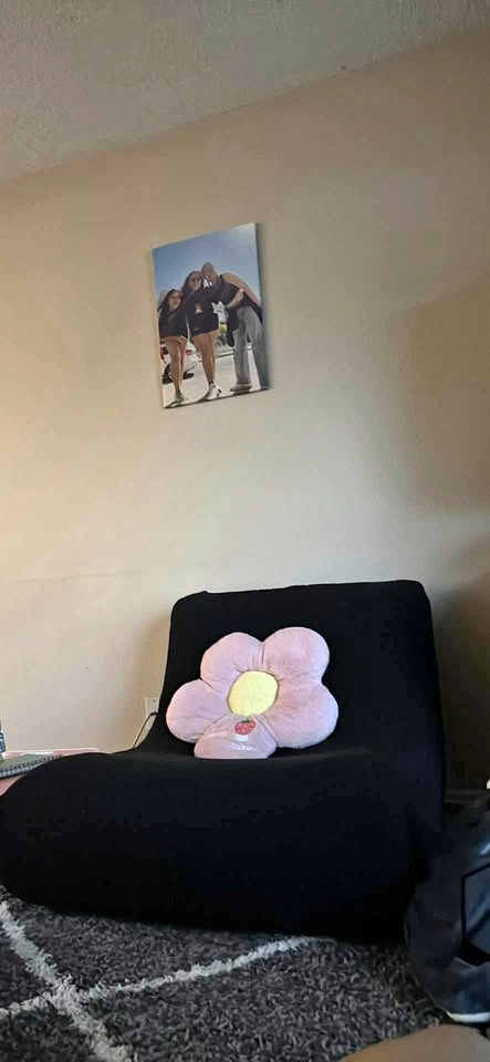 Single seater couch with cover and flower cusion on top