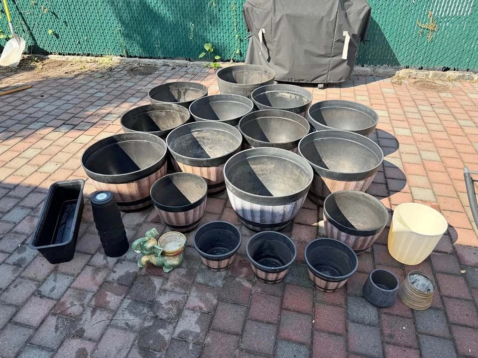 Assorted Whiskey Barrel Style Planters and Additional Pots