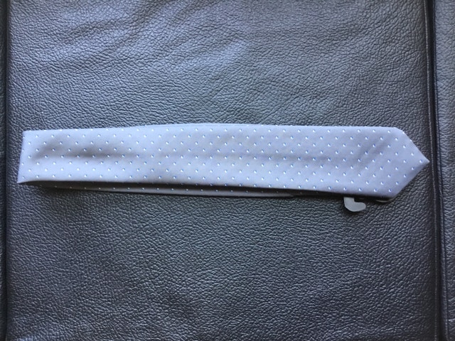 grey necktie with blue and white squares