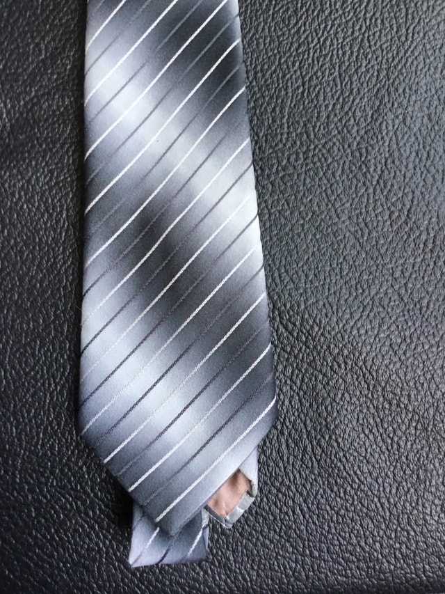 grey necktie with black and white stripes