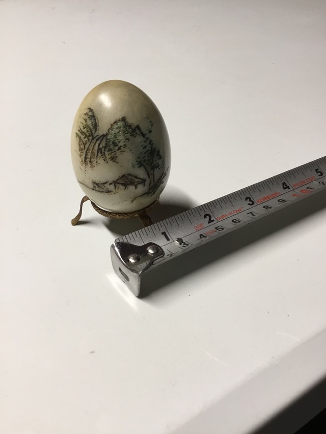 small painted stone egg with stand