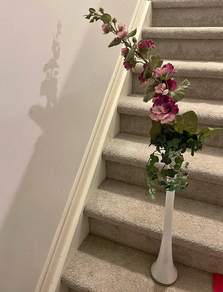 Beautiful fake flowers, ivy in white glass vase