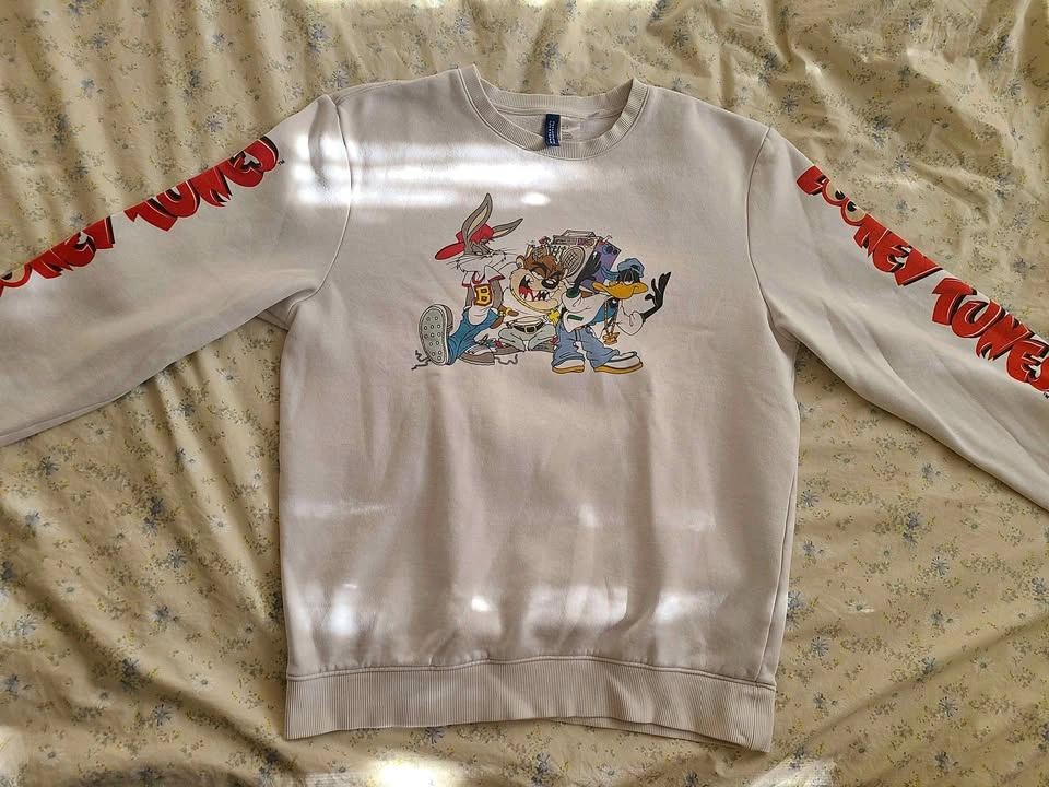 White sweatshirt with a large graphic print of Looney Tunes