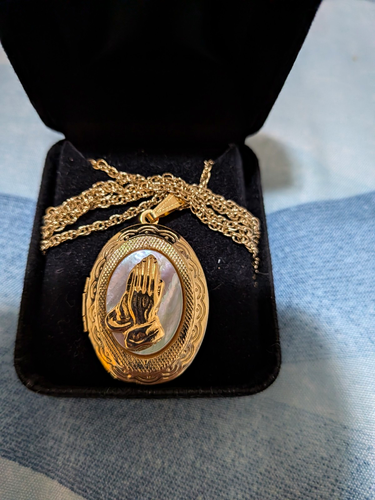 Vintage gold-tone locket necklace featuring a raised praying han