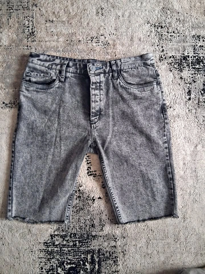 Grey acid-wash denim cut-off shorts, button fly, raw hem