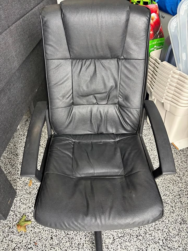 Black “leather-like” office chair on wheels