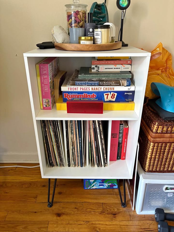 Record player stand with record in book storage shelves
