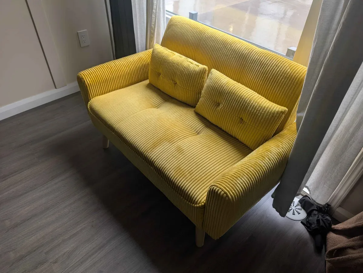 Yellow corduroy loveseat with mid-century modern styling