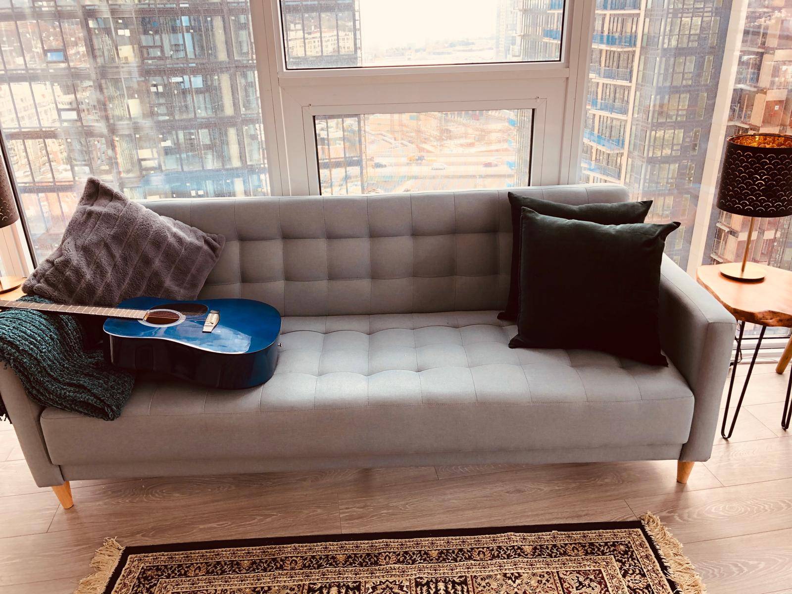 Light heather gray/green couch with biscuit tufting