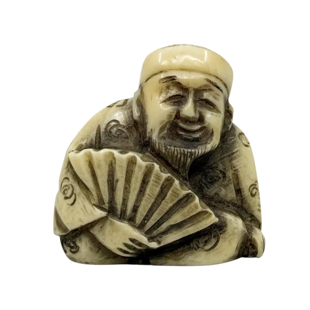 Showa period Japanese carved bone smiling man with fan netsuke