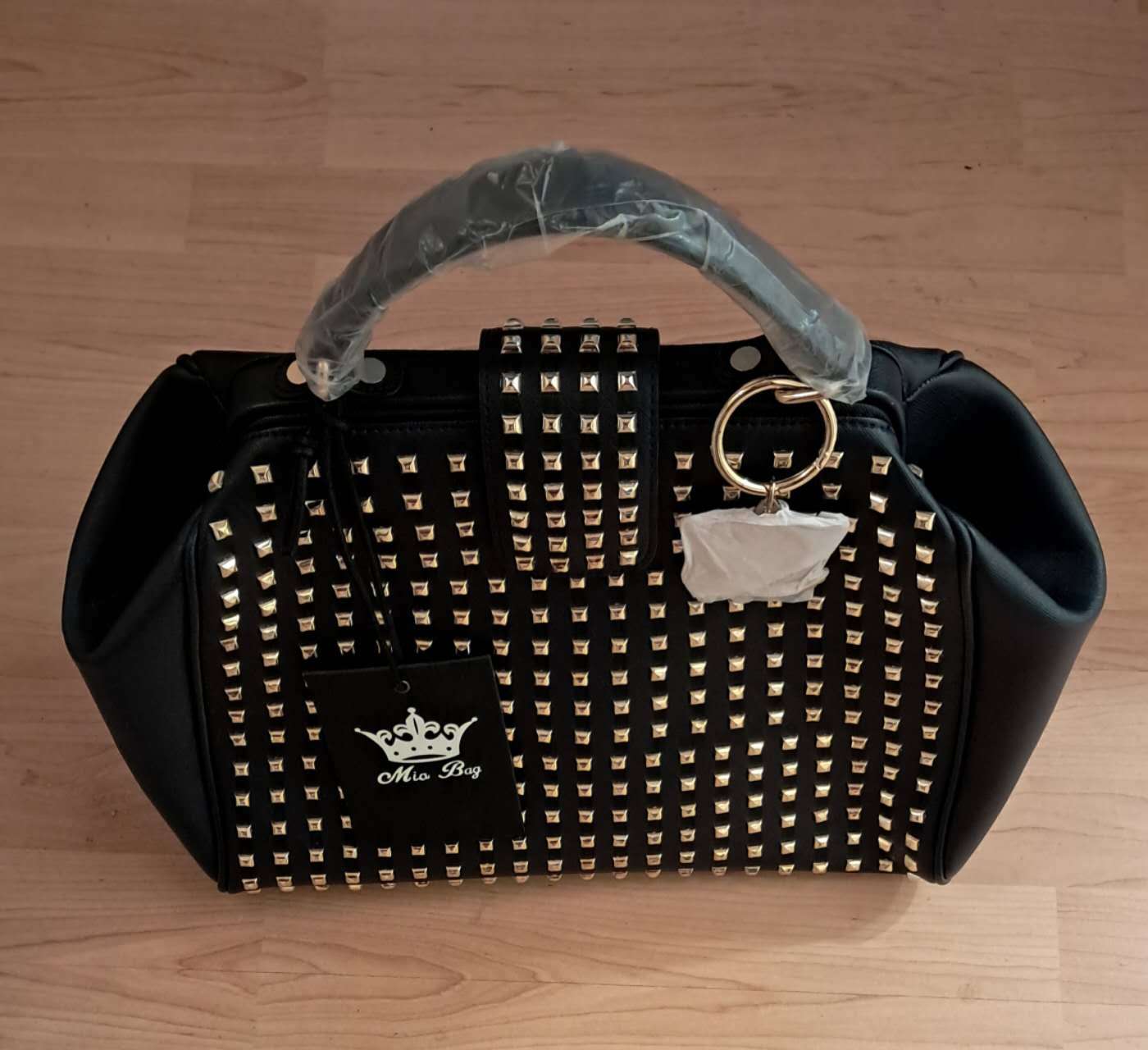 Mia Bag features a studded exterior and a crown logo label.