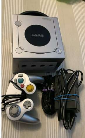 Silver Nintendo Gamecube console with controller and cords