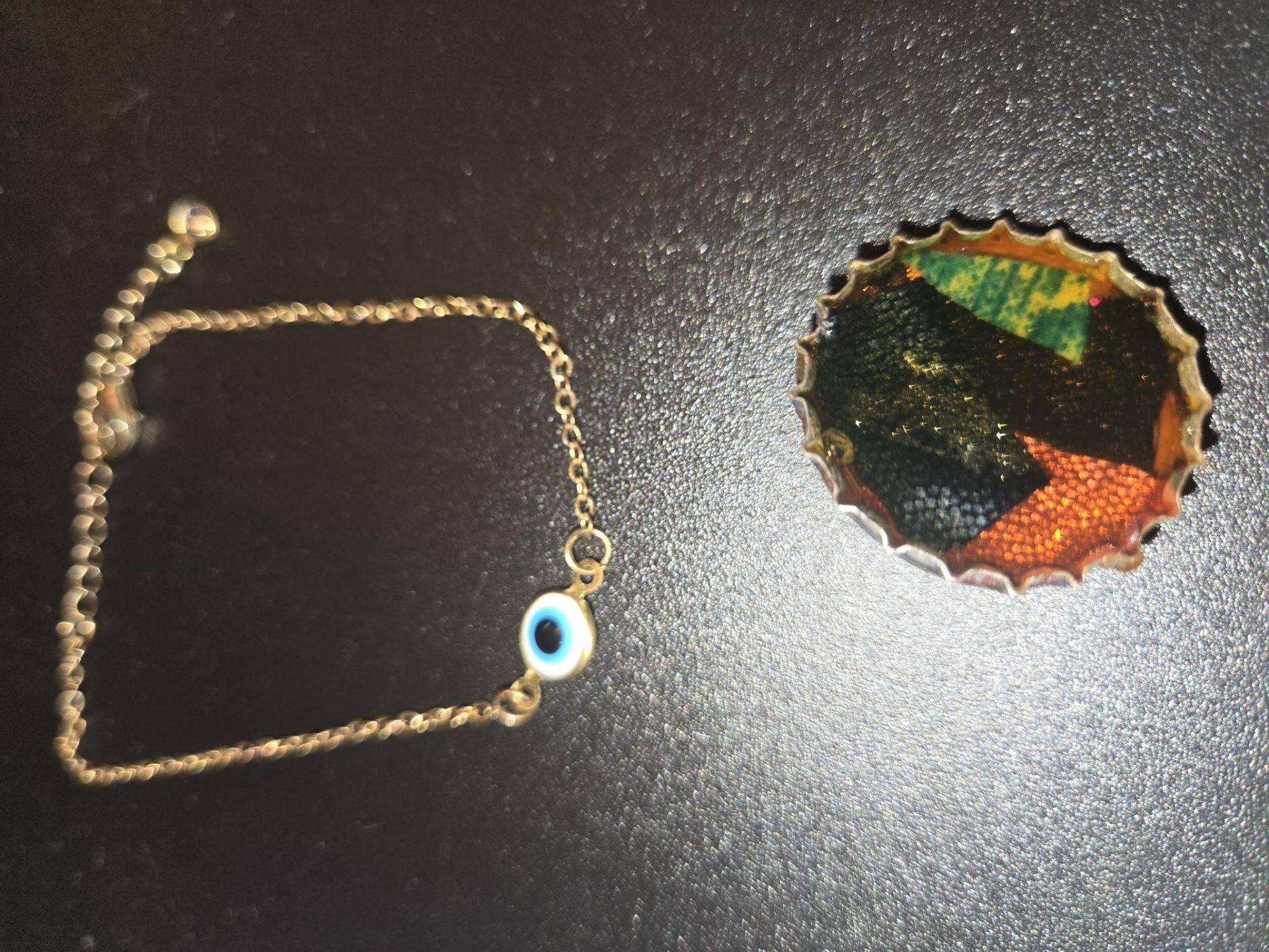 Gold-tone evil eye bracelet and unique bottle cap art pin