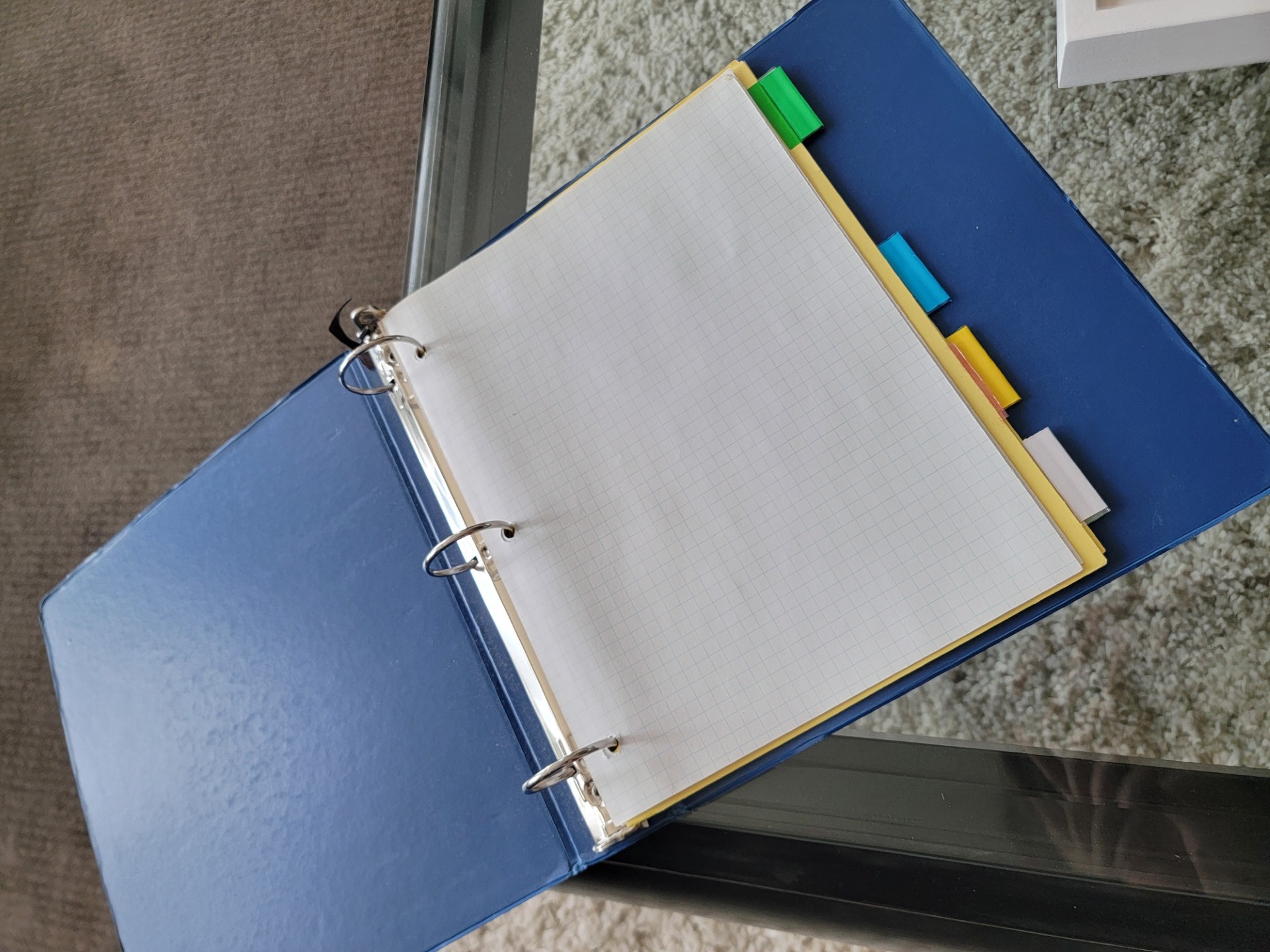 Blue school binder with dividers and few sheets of paper