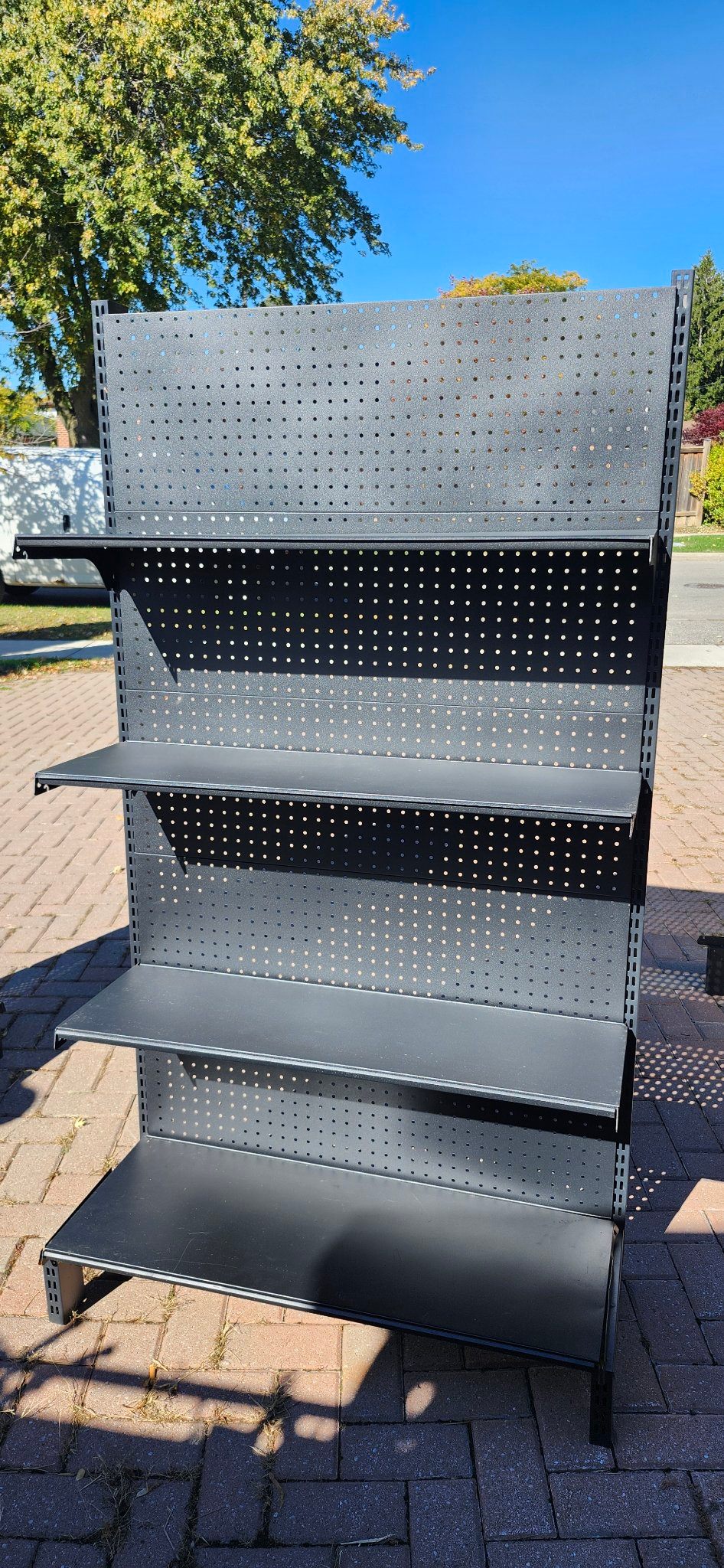 Black metal retail display shelving with pegboard back