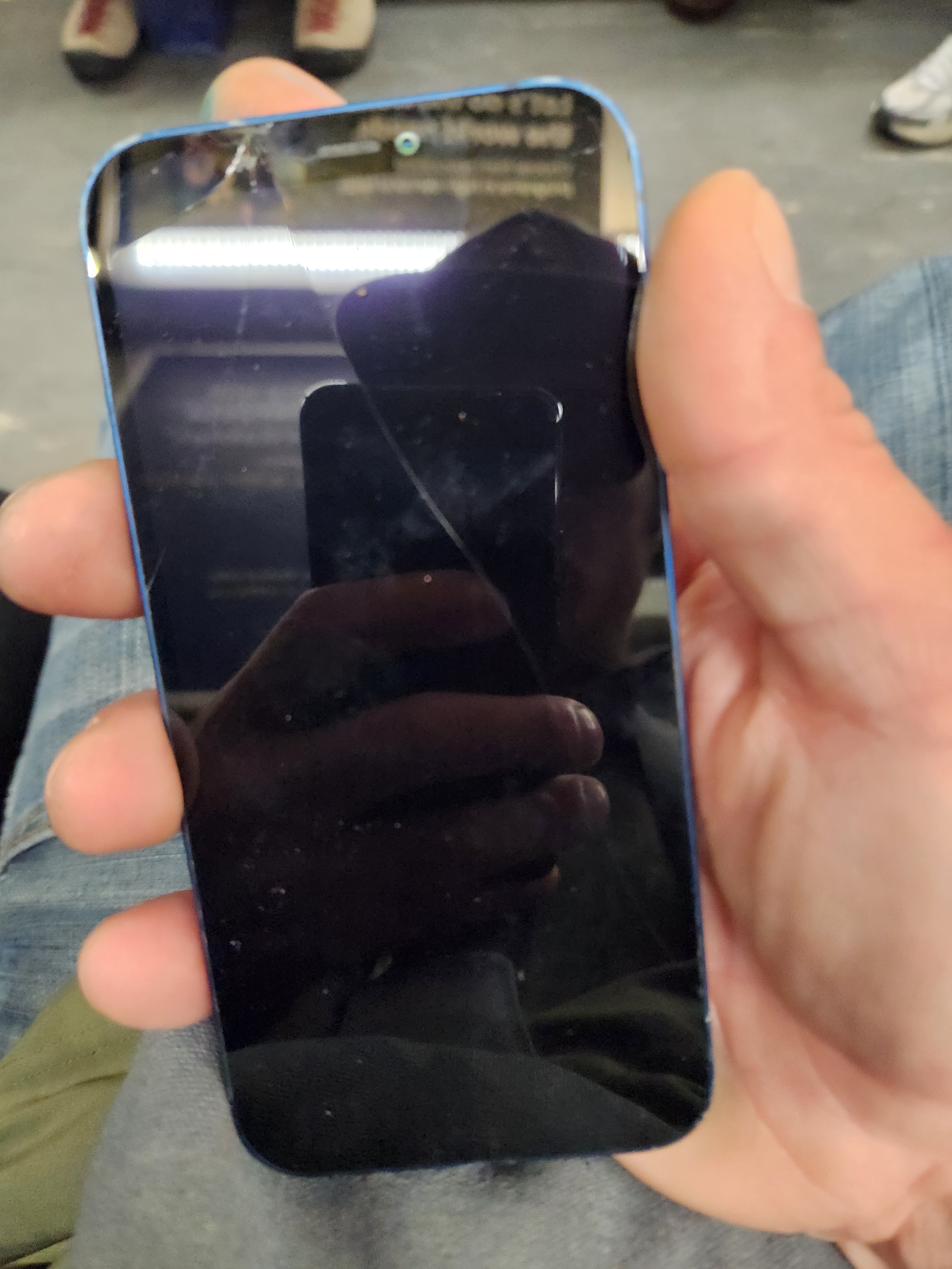 Blue iPhone 12 with cracked screen and back