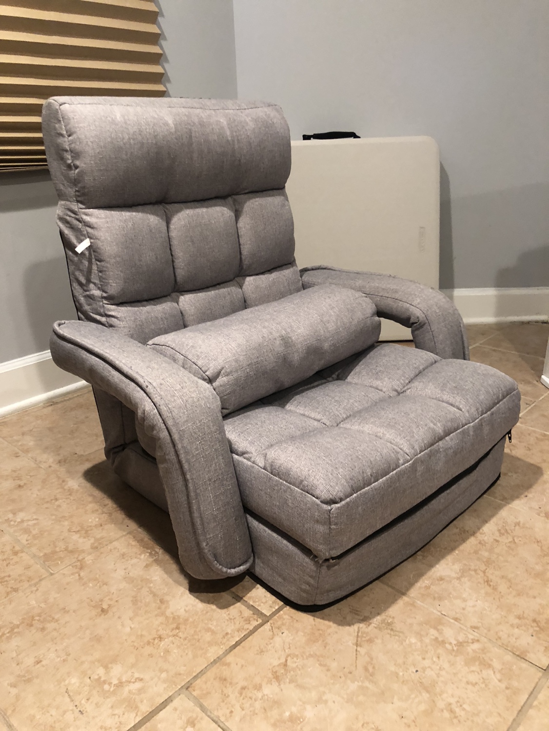 Grey floor chair with folding footrest