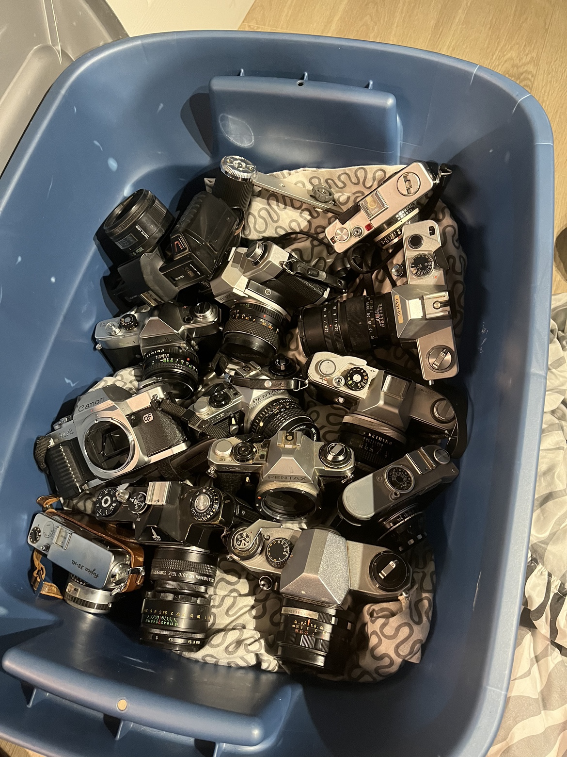 Bin of old film cameras and lenses