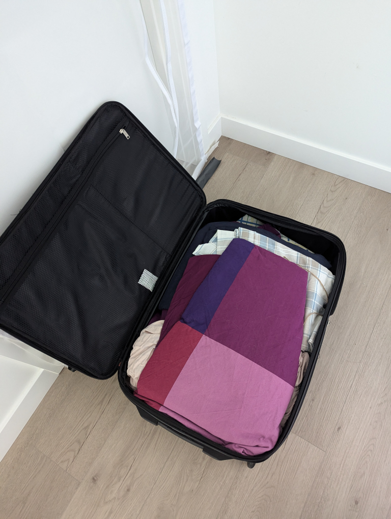 Suit case full of bed sheets