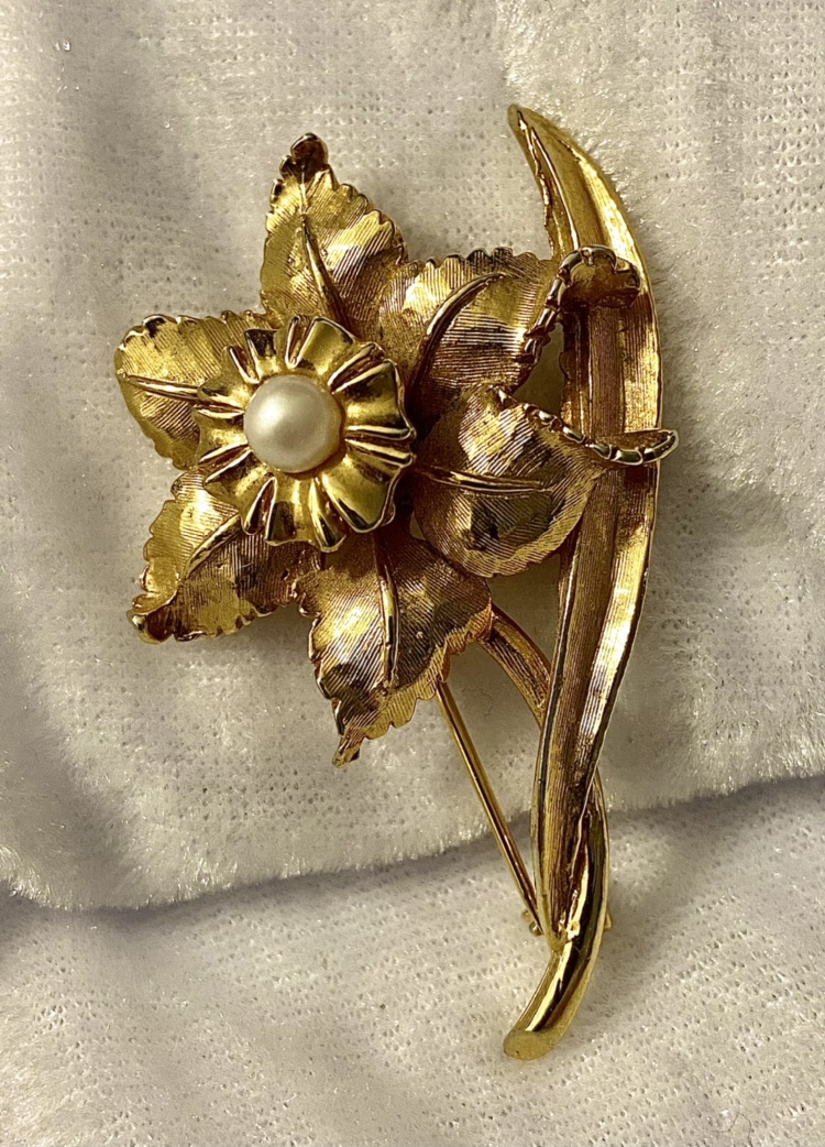 Gold toned brooch with faux pearl.