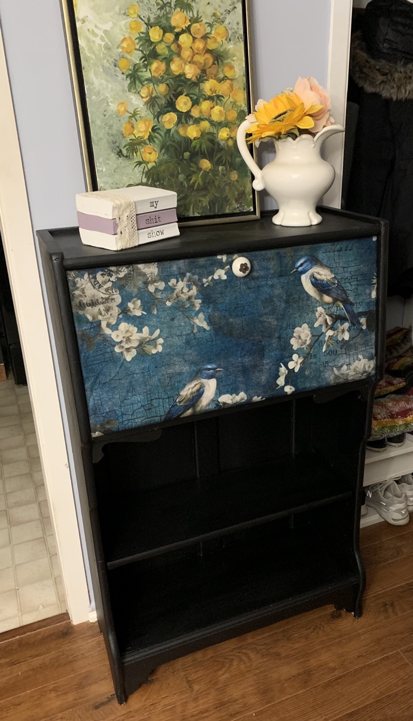 Black painted bookshelf with decorative door