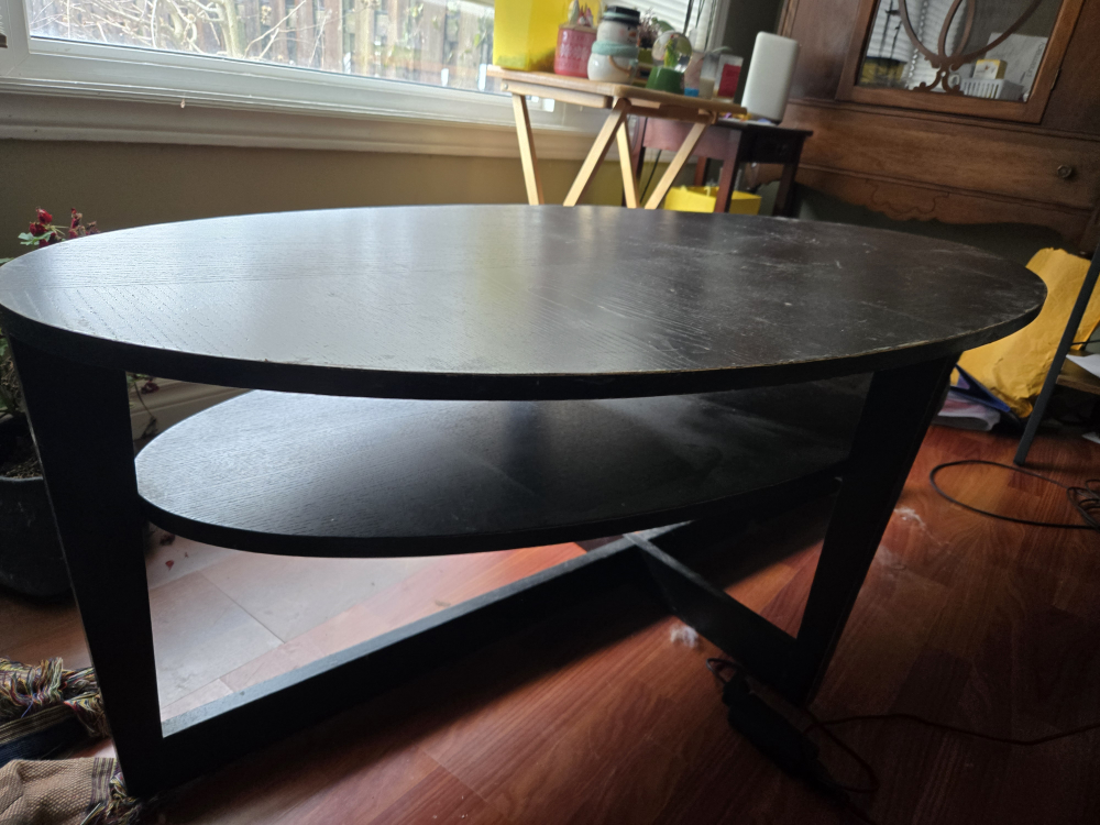Black oval coffee table with shelf