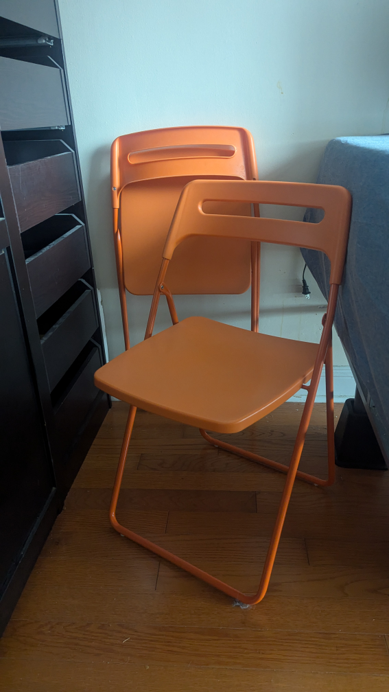 Two Orange Folding Chairs