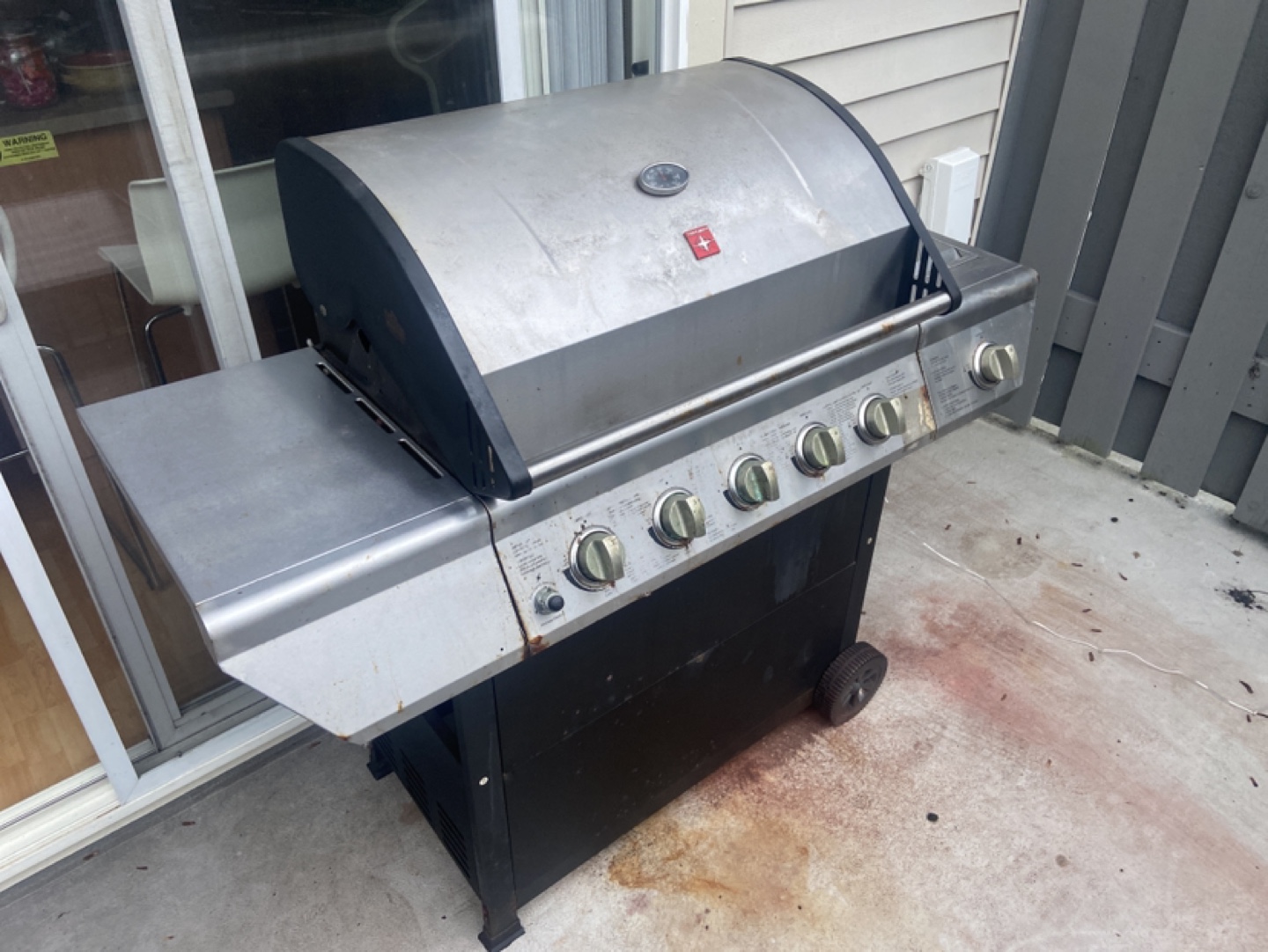 Propane BBQ with 5 burners. Includes a cover and propane tank.