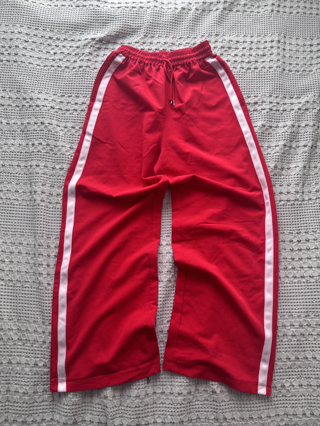Red track pants with white stripe