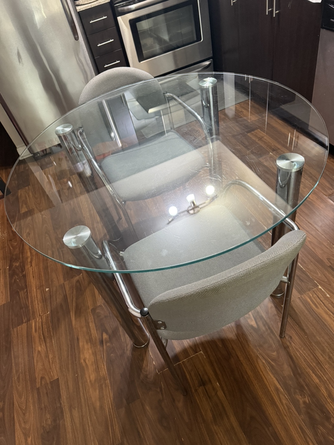 Glass-top dining table with two chairs