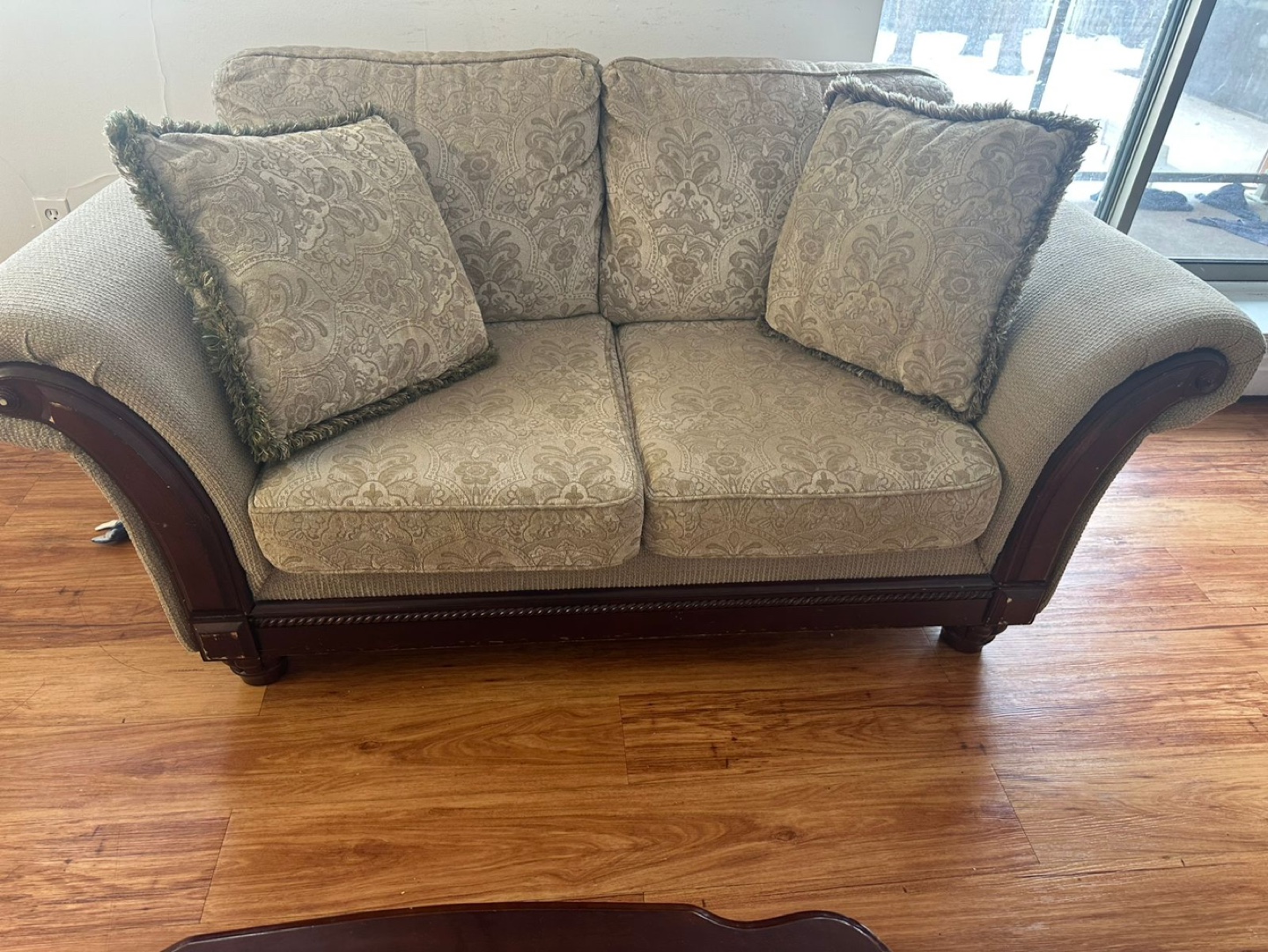 Beige loveseat with wooden arms