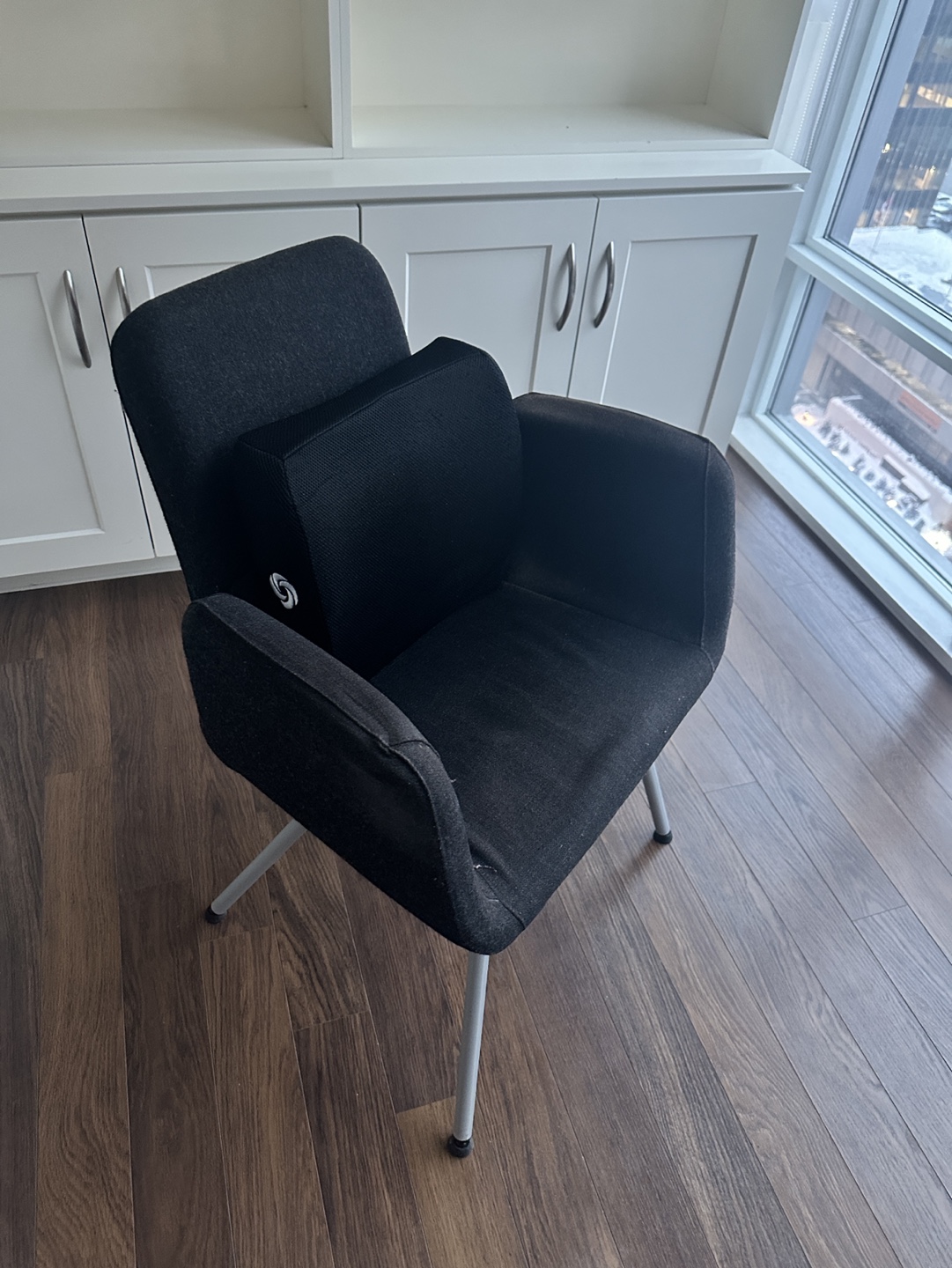 Black fabric armchair with lumbar support pillow