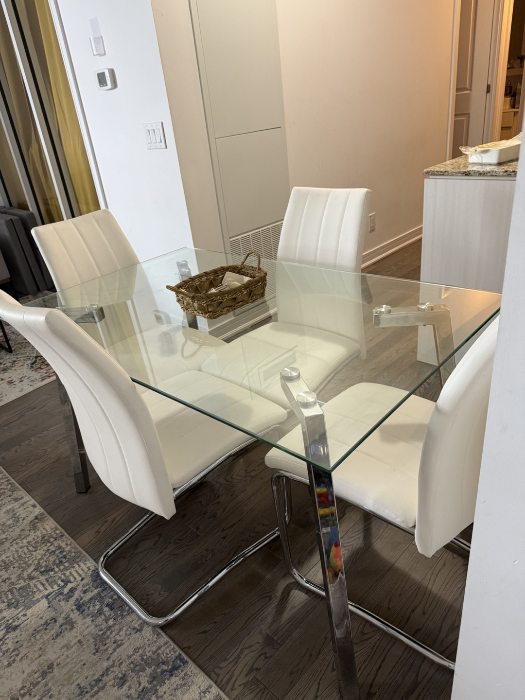 Glass Top Dining Table with Four White Chairs