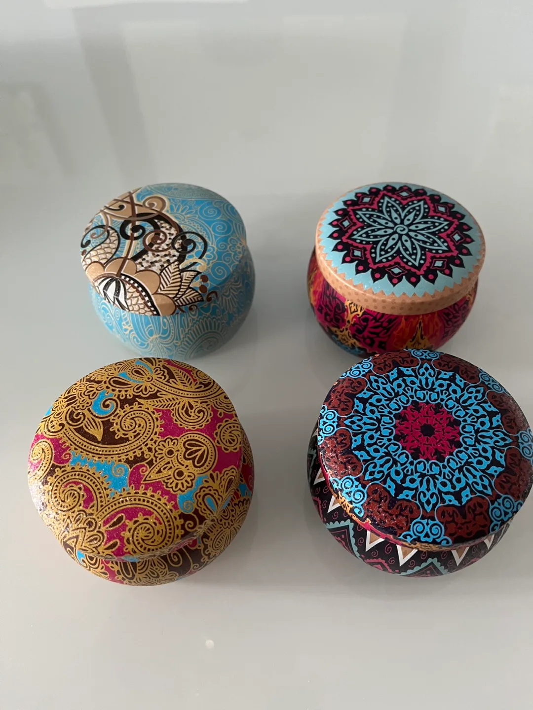 Set of four scented candles in decorative tins image indicator(2)