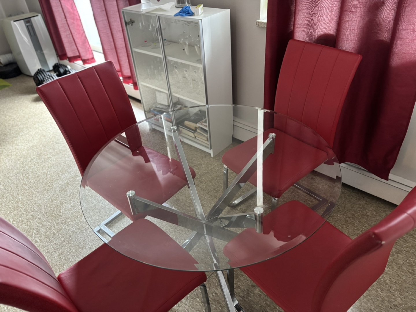 Glass-top dining table and four red chairs
