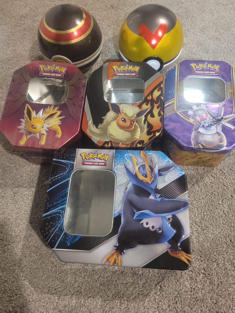 Pokemon tins and two poke balls