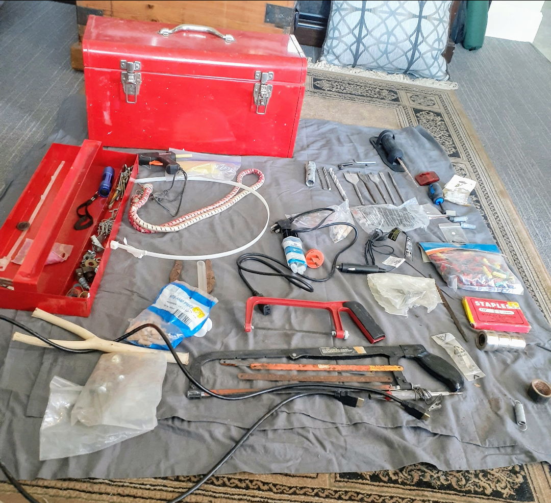 Assorted Tools and Hardware in Red Metal Toolbox