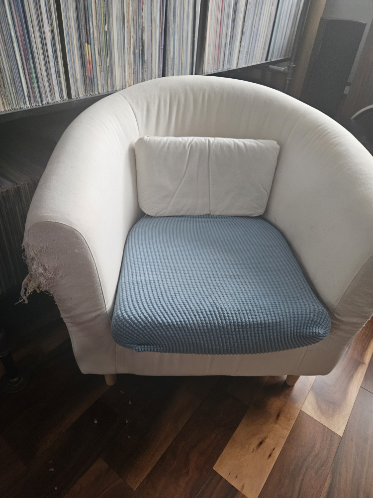 Cream coloured armchair with blue cushion cover
