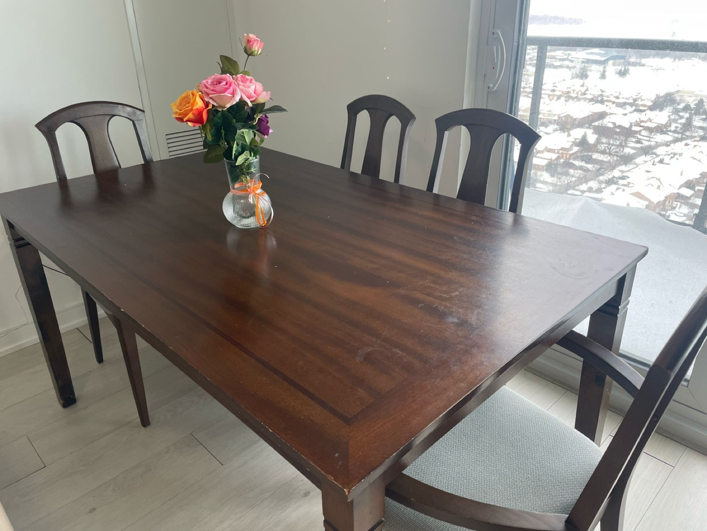 Dark brown wooden dining table and four chairs