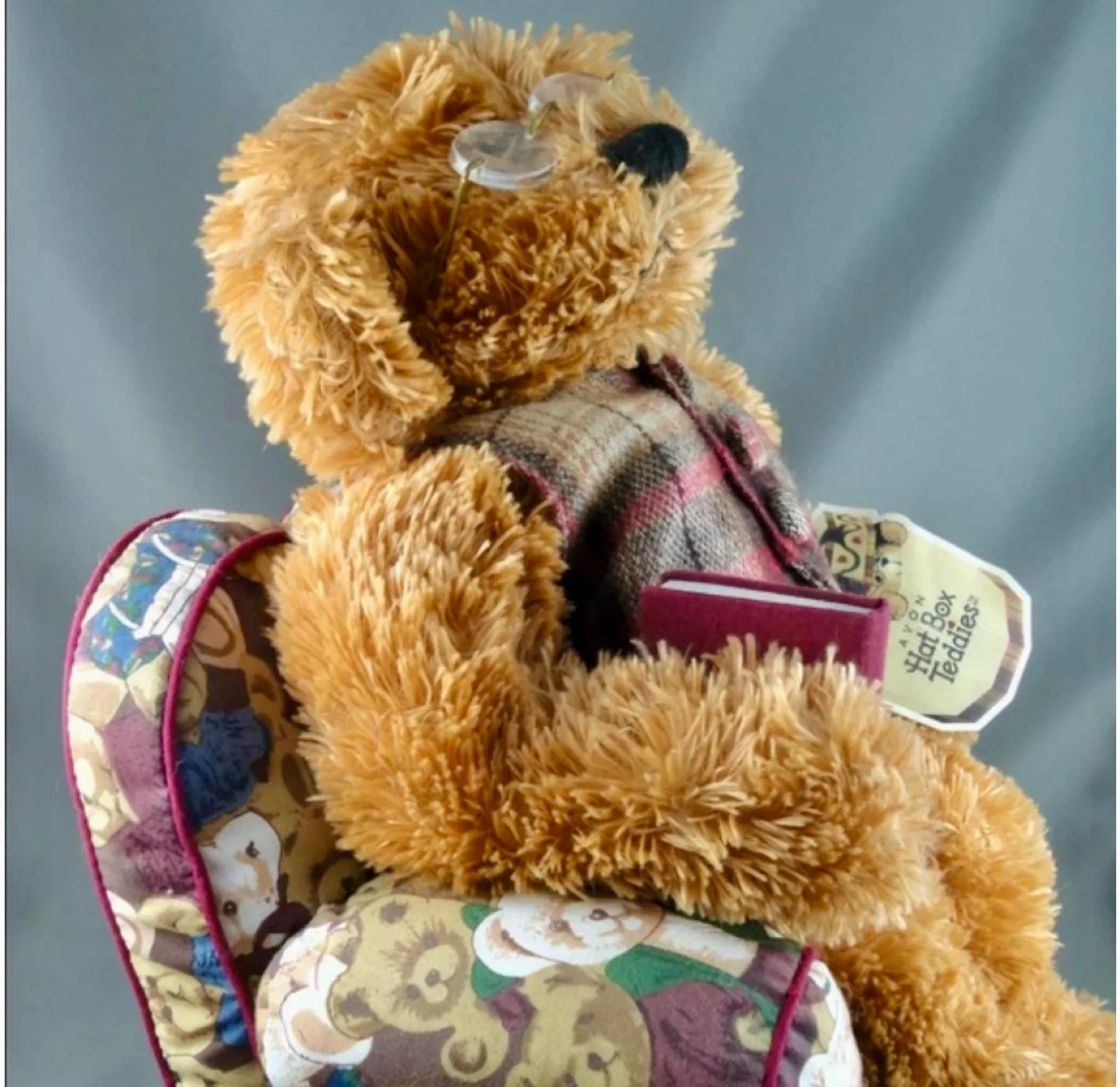 A Harrods Teddy Bear sitting in a small, overstuffed chair image indicator(2)