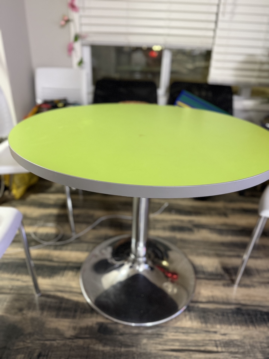 Round lime green table with 4 white sturdy chairs