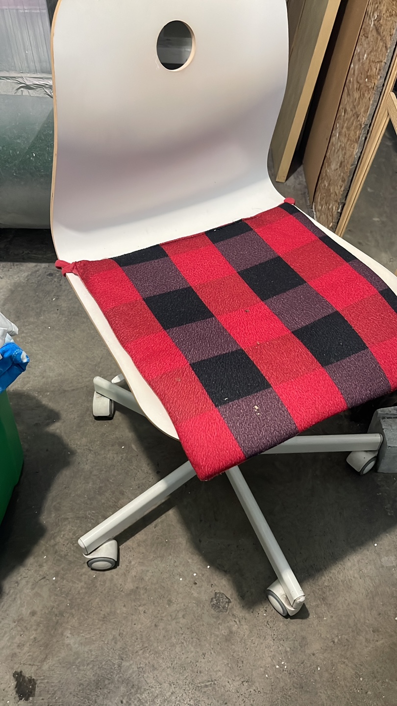 White rolling chair with  plaid cushion