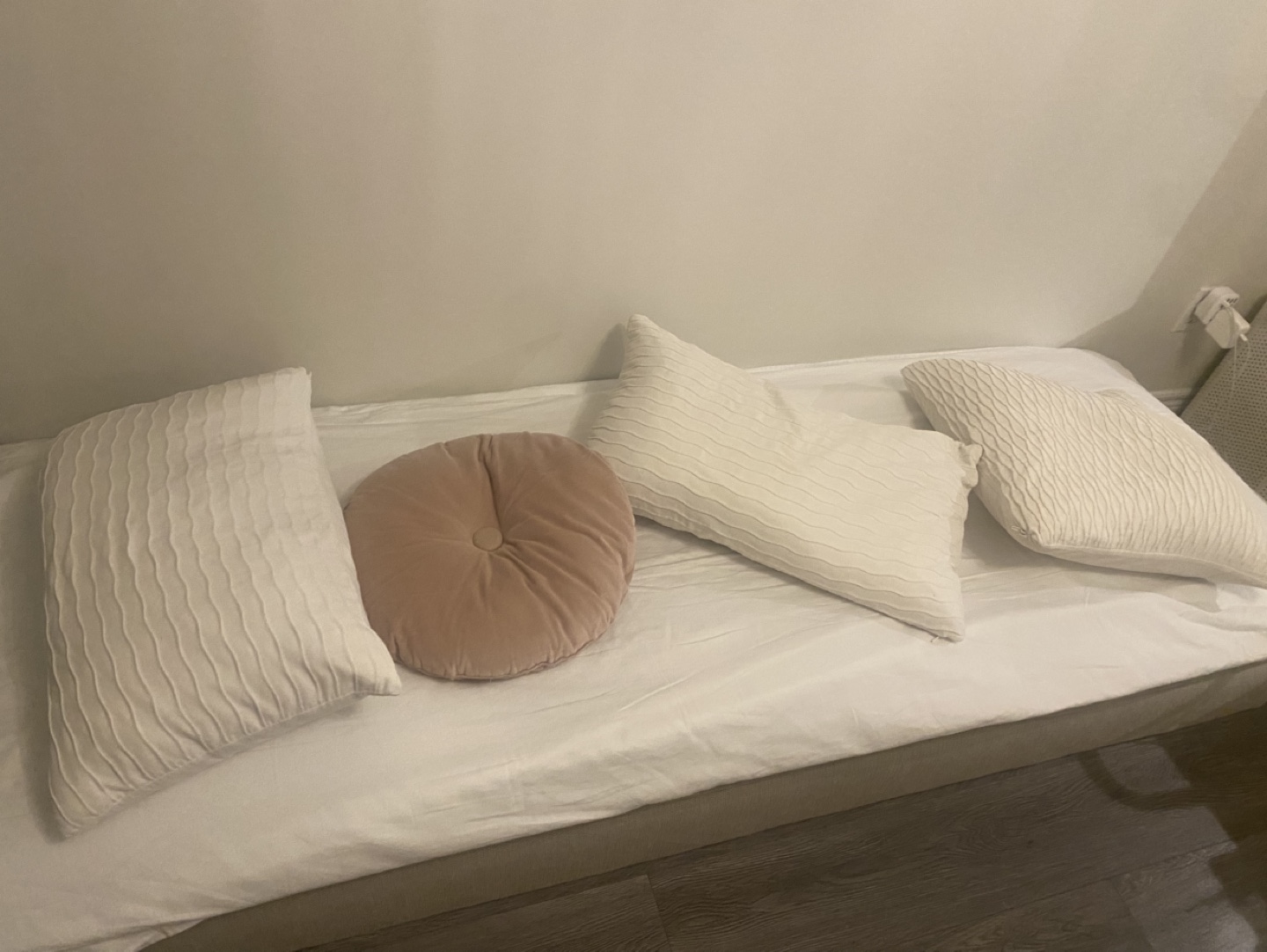 Three textured pillows and one round cushion