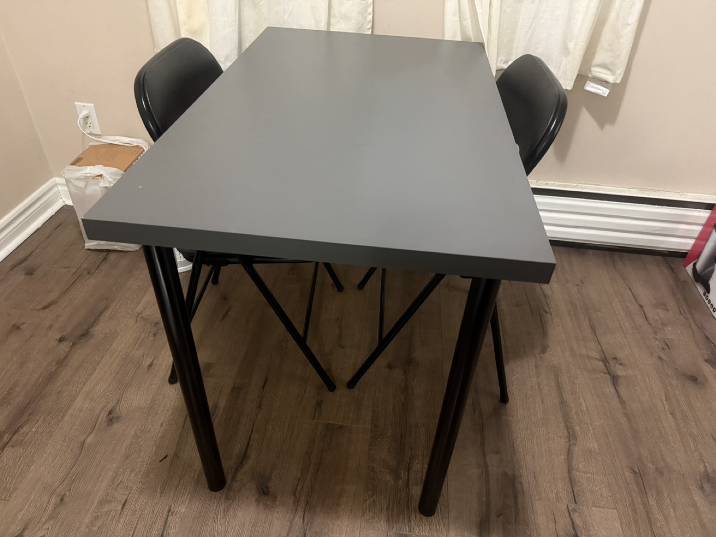 Ikea Linnmom grey table and two black folding chairs