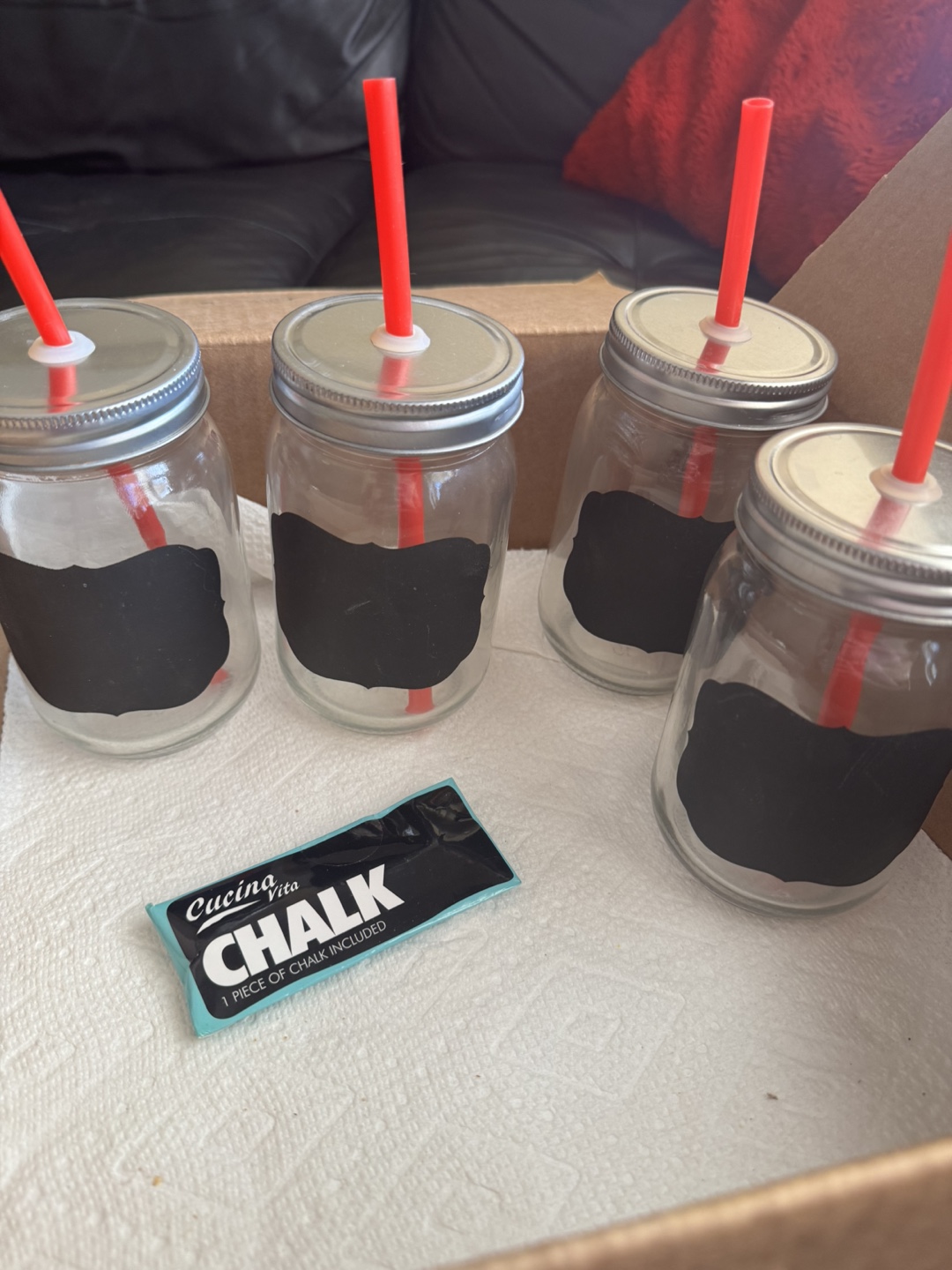 Set of four mason jar glasses with chalkboard labels and straws