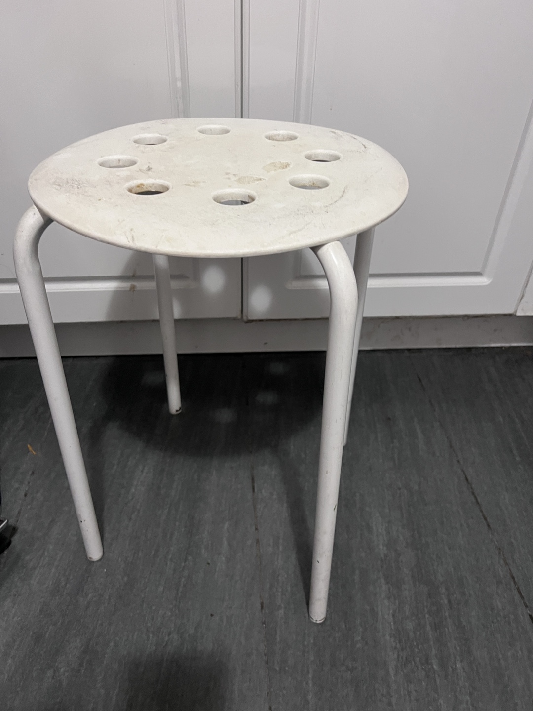 White plastic three-legged stool