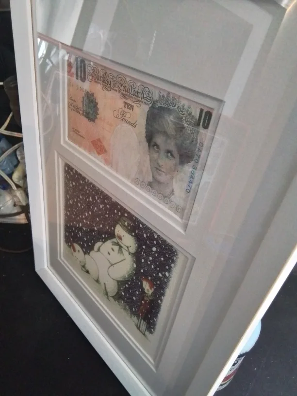 Framed Banksy artwork featuring a mod-d £10 note and a snowman image indicator(8)