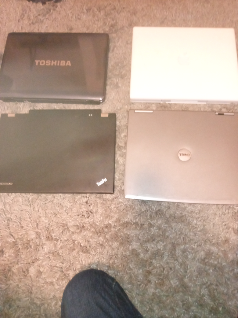 Lot of four used laptops: Toshiba, Lenovo, Apple, and Dell