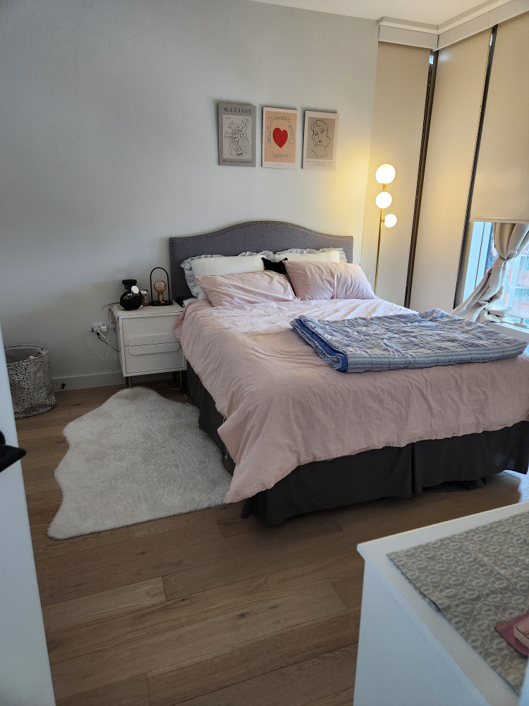 Queen-size bed with pink bedding and gray headboard