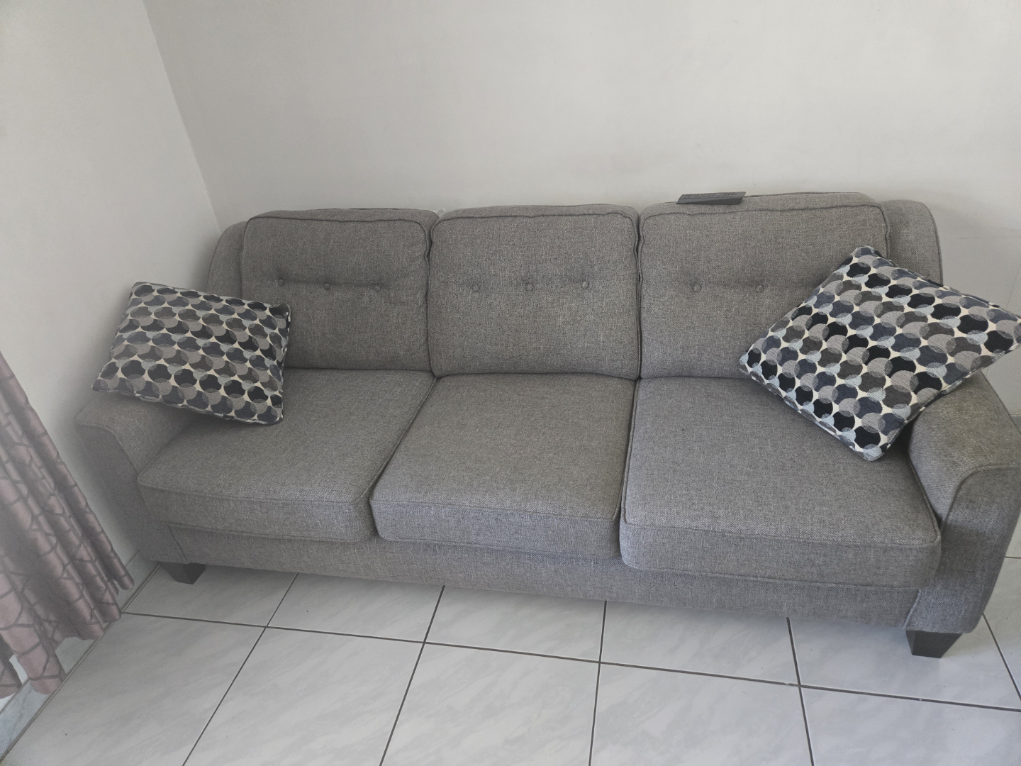 Grey fabric sofa with button tufting